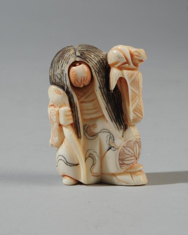 Changing Face Netsuke, Signed: Woman in kimono carrying a frog on her shoulder and an eel or snake as a staff. Her rotating face changes expression from frightening to amused. Approx. 1 7/8" H.