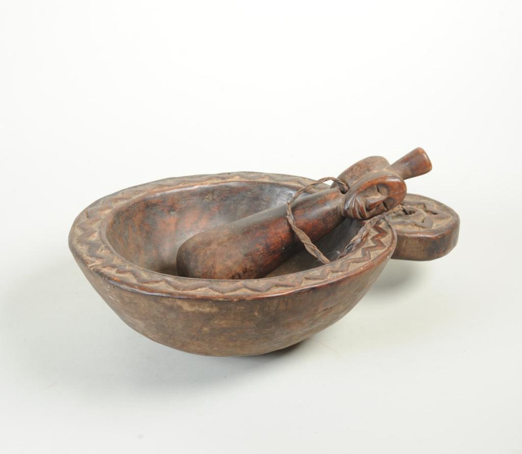 African Bowl & Mortar: Wood bowl with relief carved saw tooth rim, with large disc handle with relief carved star. Pestle attached with braided leather cord has anthropomorphic janiform handle. Possibly for ritual / medicin