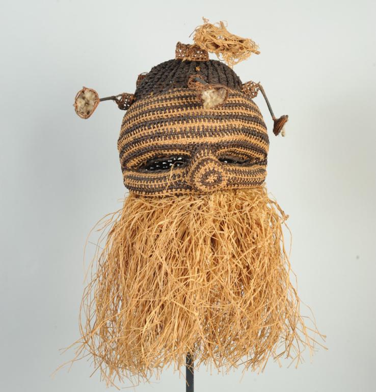 African Woven Raffia Mask: Possibly Kuba / Binji. Woven fiber cap mask with eye holes and dimensional nose, with wicker stalk-like projections (damaged)each with a small basket or cup finial (damaged), the lower face with a thi
