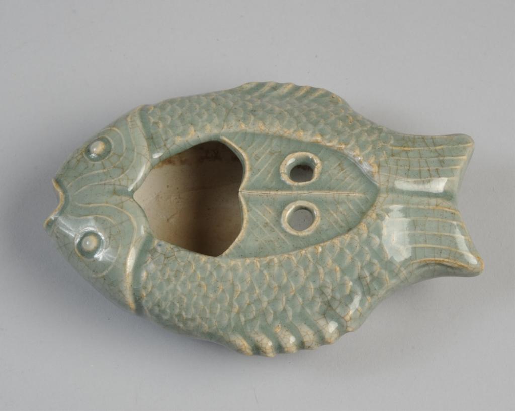 Celedon Twin Fish Brush Washer & Holder: Details of twin fish carved or molded in relief under the celadon crackle glaze. Opening for washing brushes and two small holes, possibly for holding brushes. Rests on four low, unglazed feet. Asian,