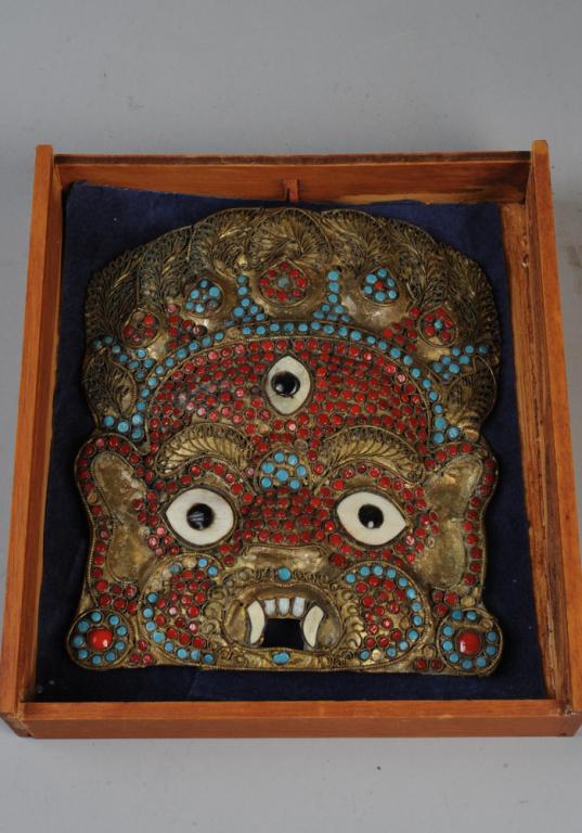 Tibet or Nepal Mahakala Mask: Repousse Buddhist brass mask with inset bone and turquoise blue and red stones or glass. Includes glass front wooden case. Mask, approx. 7 1/2" x 6 1/2". Case, approx. 9" x 8" x 1 3/4". Provenance: Es