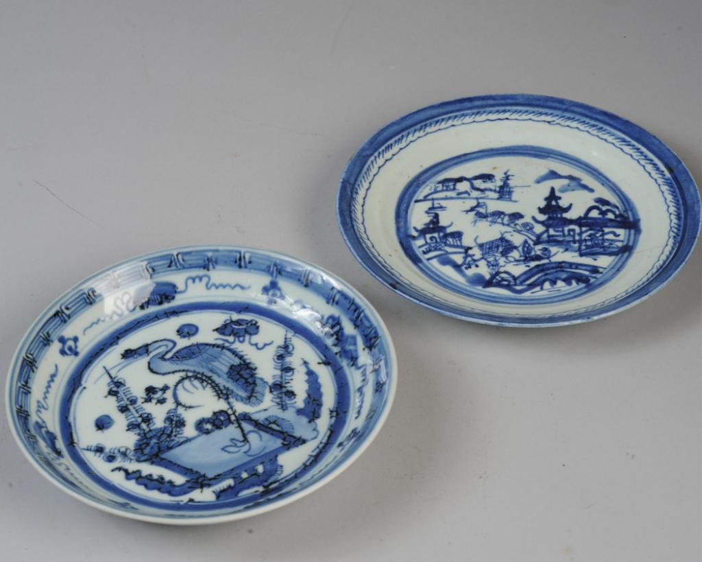 Two Antique Chinese Blue & White Plates: One plate or shallow bowl with upturned rim, the center with a crane standing on one leg and surrounded by foliage and auspicious objects, with key border. Unidentified mark within double circle in un