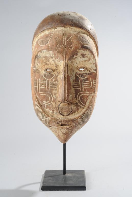 Fang Mask, Gabon: With incised designs or symbols whitened with kaolin, heart-shaped facial plane, long nose with metal ring. On custom gallery stand. Mask, approx. 16 1/2" x 8 1/2" x 5". Provenance: Estate of Thomas M