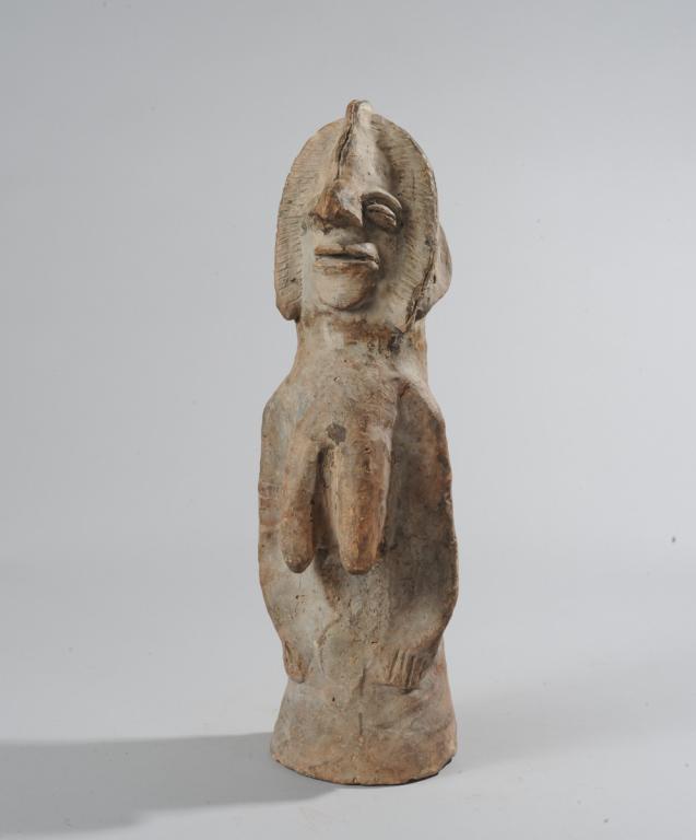 Dogon ? Terracotta Figure: Columnar terracotta female figure with cranial ridge leading to prominent nose, with tri-lobed coiffure, long narrow breasts, arms close to the body, and no legs. Possibly Dogon, Mali. Old repairs. Sh