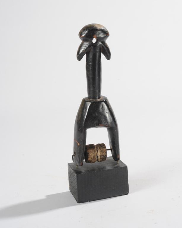 West African Heddle Pulley: The finial of abstract form, likely representing a janiform hornbill bird. Ivory Coast. On custom gallery stand. Total height aprox. 9 1/2". Provenance: Estate of Thomas McNemar, (1931-2020.) McNemar