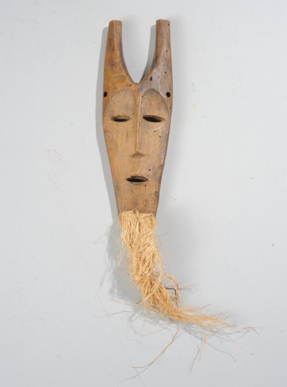 Lega Miniature Mask: Small, nearly flat mask with horns, fiber beard, and simplified but compelling features. Approx. 8 3/4" x 3" (excluding beard.) Provenance: Estate of Thomas McNemar, (1931-2020.) McNemar lived and col