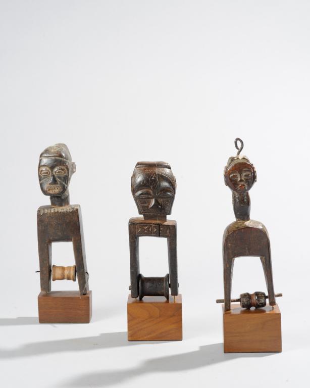 Three Figural West African Heddle Pulleys: Baule / Guro, Ivory Coast. All on custom gallery stands. Tallest, approx. 10 3/4" total height. Provenance: Estate of Thomas McNemar, (1931-2020.) McNemar lived and collected throughout Central and We