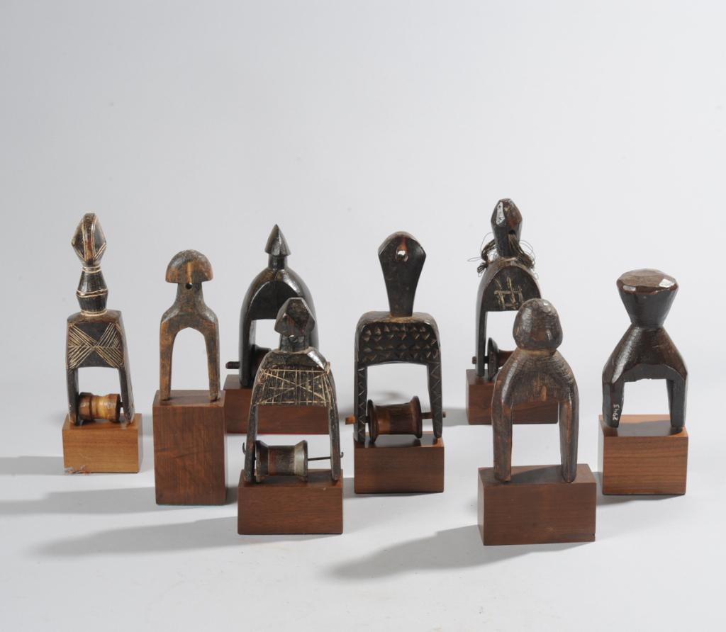 Lot African Heddle Pulleys: Eight heddle pulleys, various tribes including Senufo, Ivory Coast. All on custom gallery stands. Tallest, including stand, approx. 9" H. Provenance: Estate of Thomas McNemar, (1931-2020.) McNemar liv