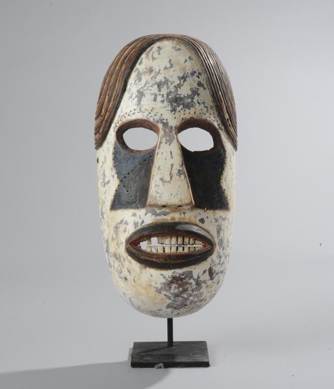 African Mask, Igbo ? Idoma?: Anthropomorphic mask, white with dramatic black shadows beneath the large eye holes extending the length of the triangular nose, the large mouth with blackened lips opened to reveal two rows of square