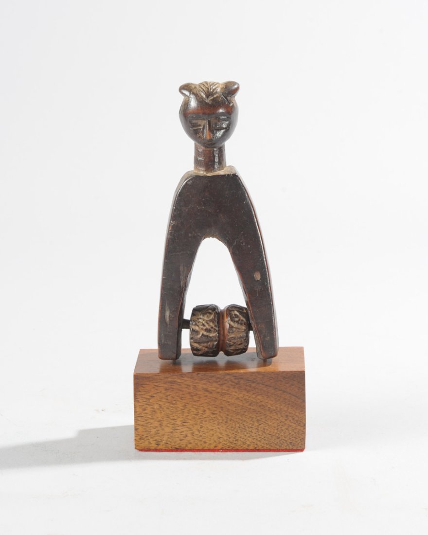 Guro Heddle Pulley: Figural heddle pulley, the finial a head with lobed coiffure, delicate features. On custom gallery base. Total height, approx. 7 1/2". Provenance: Estate of Thomas McNemar, (1931-2020.) McNemar lived