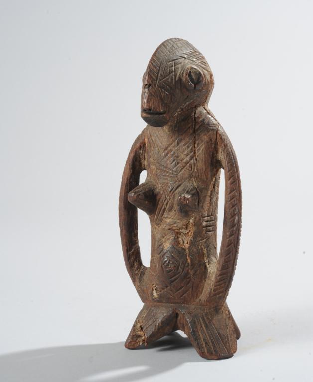 African Carved Wood Figure: Small carved wood figure, the head resembling a bird or fish, with huge hollow eyes on either side of the head, the cranial ridge extending from the back of the head to the end of the nose, the body u