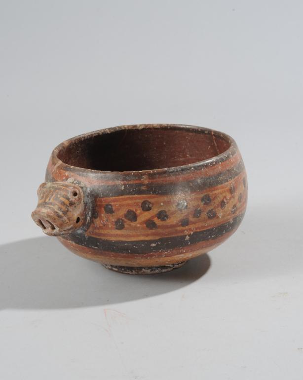 Pre Columbian Animal Effigy Bowl: Round bowl on low foot with molded pig head projecting from one side with rattle inside, the bowl with red and black polychrome bands of lines, diagonals and dots. Restorations. Approx. 3 1/2" H, 7 "