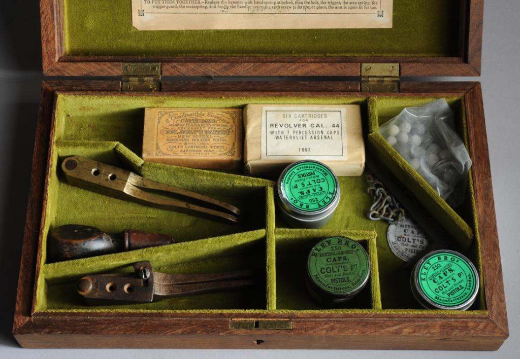 Box with Pistol Parts: With three boxes percussion caps, 44 caliber bullets from Watervliet Arsenal, two double cavity bullet molds. Lid with instructions for loading a Colt pistol. Box approx. 11 1/4" x 7" x 2". Provenance