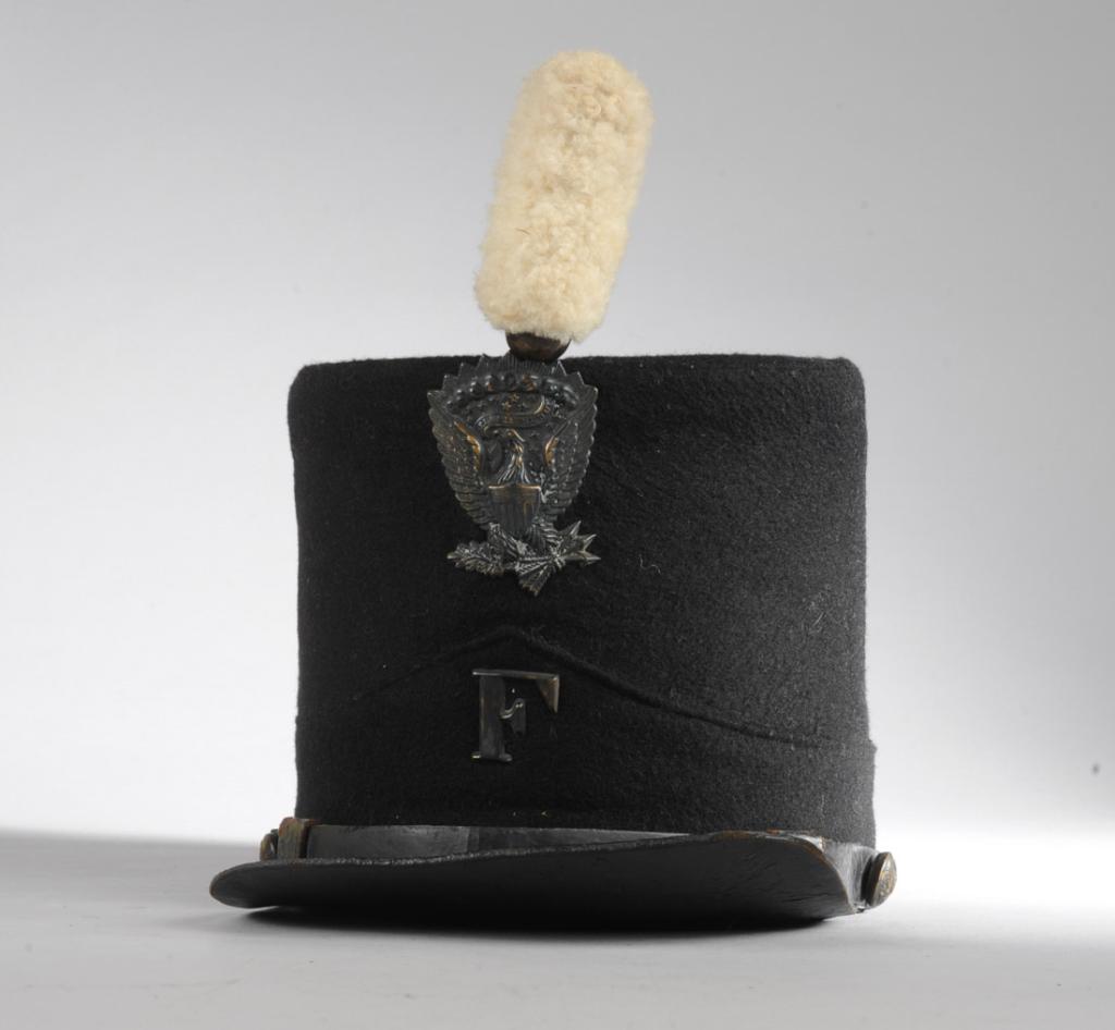 Civil War Shako Cap: Wool felt Infantry shako cap, the badge with left facing eagle and 13 stars, Company F, white pompom. Leather bill and strap, brass buttons with left facing eagle. Minor wear to interior. Believed to