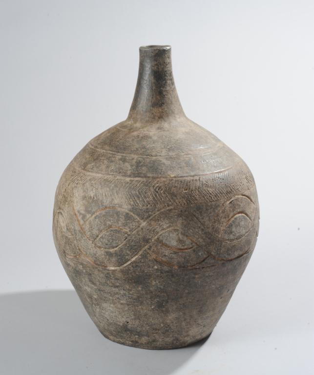 Igbo / Ibo Pot, Nigeria: Dark gray pottery vessel with long neck, wide body, flat base, incised decoration. Approx. 17" H. Provenance: Estate of Thomas McNemar, (1931-2020.) McNemar lived and collected throughout Central and 