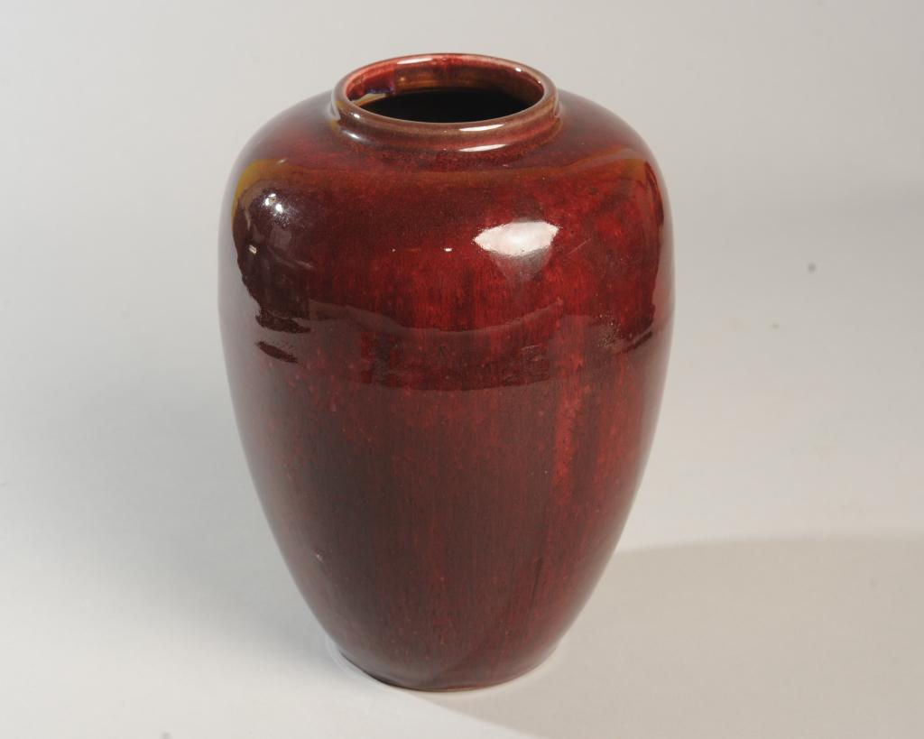 Chinese Qing Jun Red Glazed Vase: Urn shaped vase with deep sang de boeuf flambe glaze. Glaze trimmed at foot, foot rim also trimmed. According to an early 20th C. note in ink inside the vase, (written by an American woman who lived i