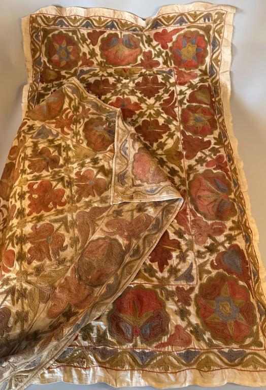 Two Afghanistan Suzani Textiles: Floral patterned wool embroidery on cotton in muted shades of rust, blue, green and gold. Approx. 36" x 60" and 4`" x 62".
