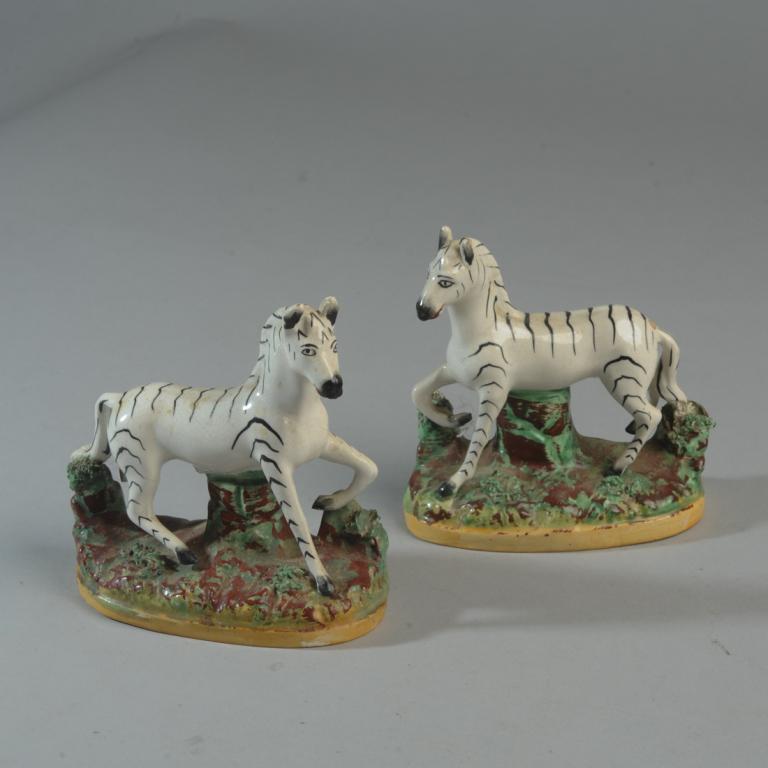 Pair Antique Staffordshire Zebras: Unmarked, probably 19th C. One has lost a back hoof, (does not show when displayed.) Approx. 5" H.