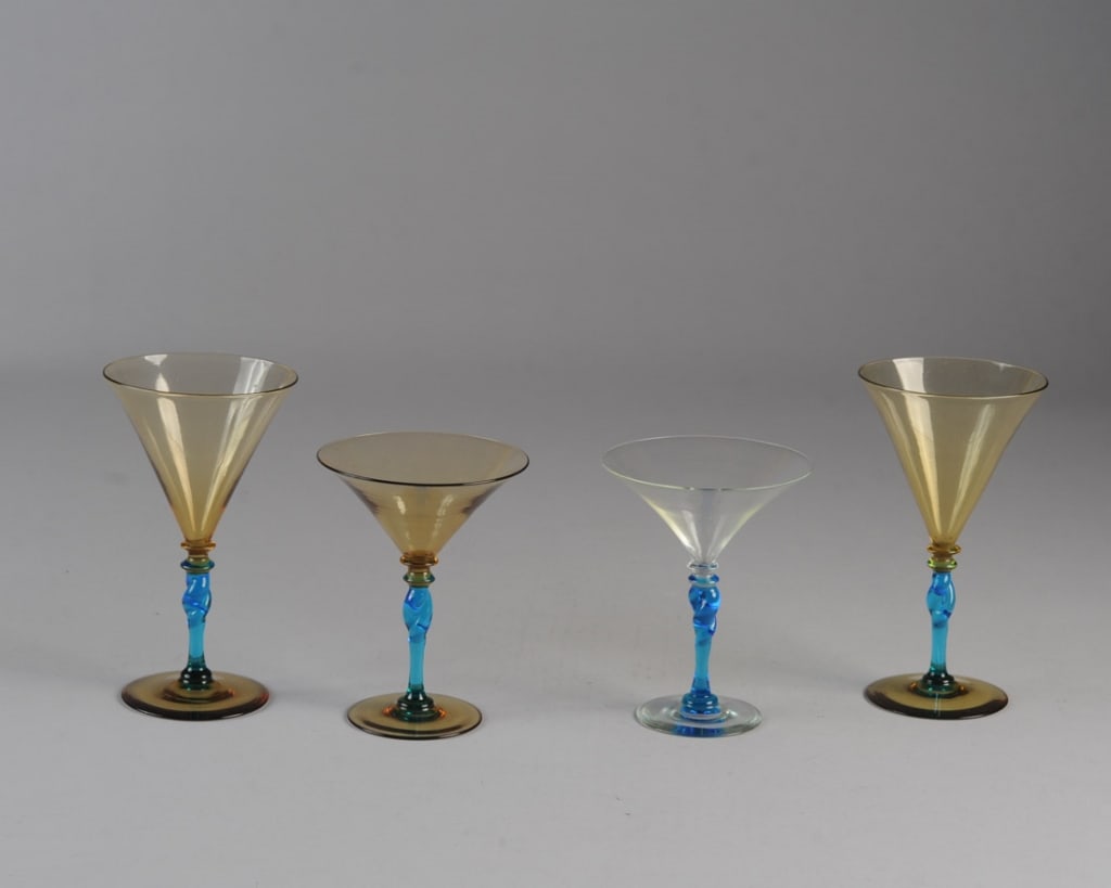 Four Steuben Twisted Stem Drinking Glasses: Two martini glasses (one clear & blue, the other amber & blue) and two wine glasses (both amber & blue). Two signed, no visible chips, cracks or repairs. H: approx. 5 3/8" and 7".