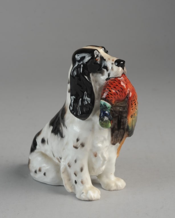 Royal Doulton Spaniel with Pheasant Hn1138: Black and white spaniel seated with pheasant in mouth. Royal Doulton mark in green to base, with hand painted H n 1138 with three dots. Very minor flea bites felt along edge of back foot. Approx. 5 1/