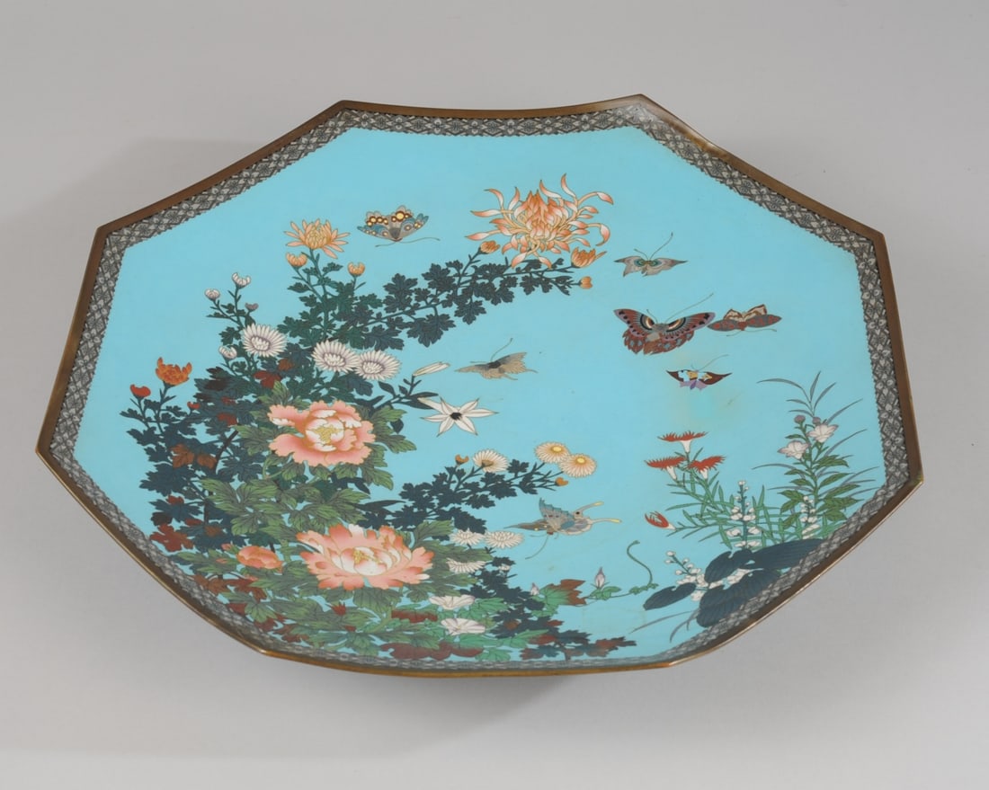 19" Japanese Meiji Cloisonne Charger: Large octagonal charger with butterflies among peonies, chrysanthemums and other flowers on a turquoise blue enamel ground. Fine color and detail. Verso with allover scrolling wire. Approx. 19" D. Pro