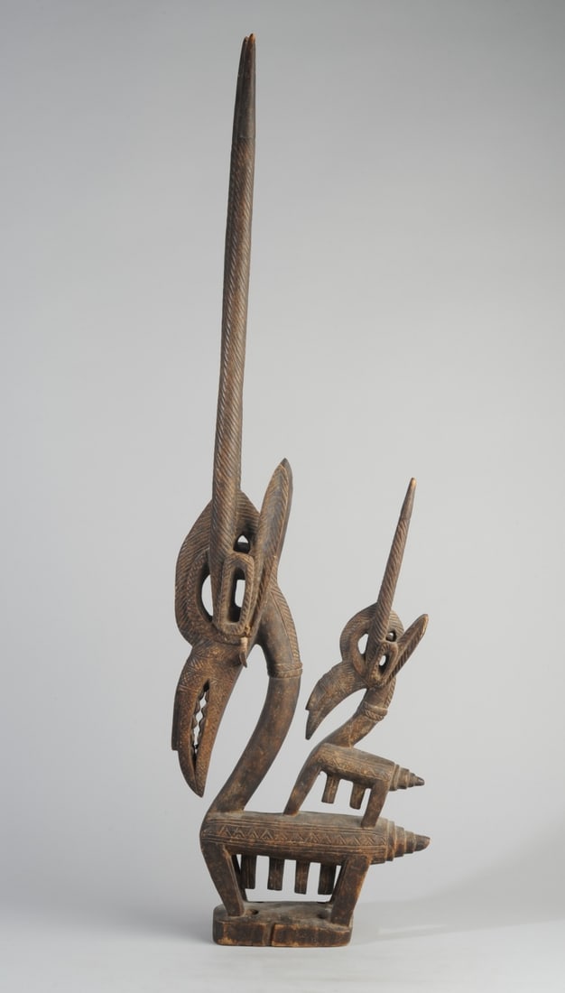 Female Chiwara Head Crest, Mali: Bamana / Bambara tribe carved wood headdress with the figure of a stylized female antelope, her baby on her back. Unusual openwork carved detailat base of horns. Long, beak-like snouts, the mother's w