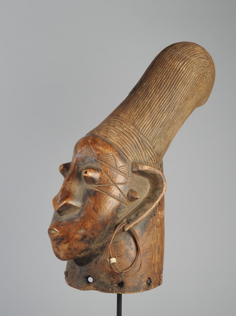 Mangbetu Head Crest / Sculpture: Carved wood Mangbetu head with the high, compressed head and dramatic coiffure conforming to Mangbetu ideals of beauty. With bulging eyes and well-formed nose flattened at the top, small mouth. Large 
