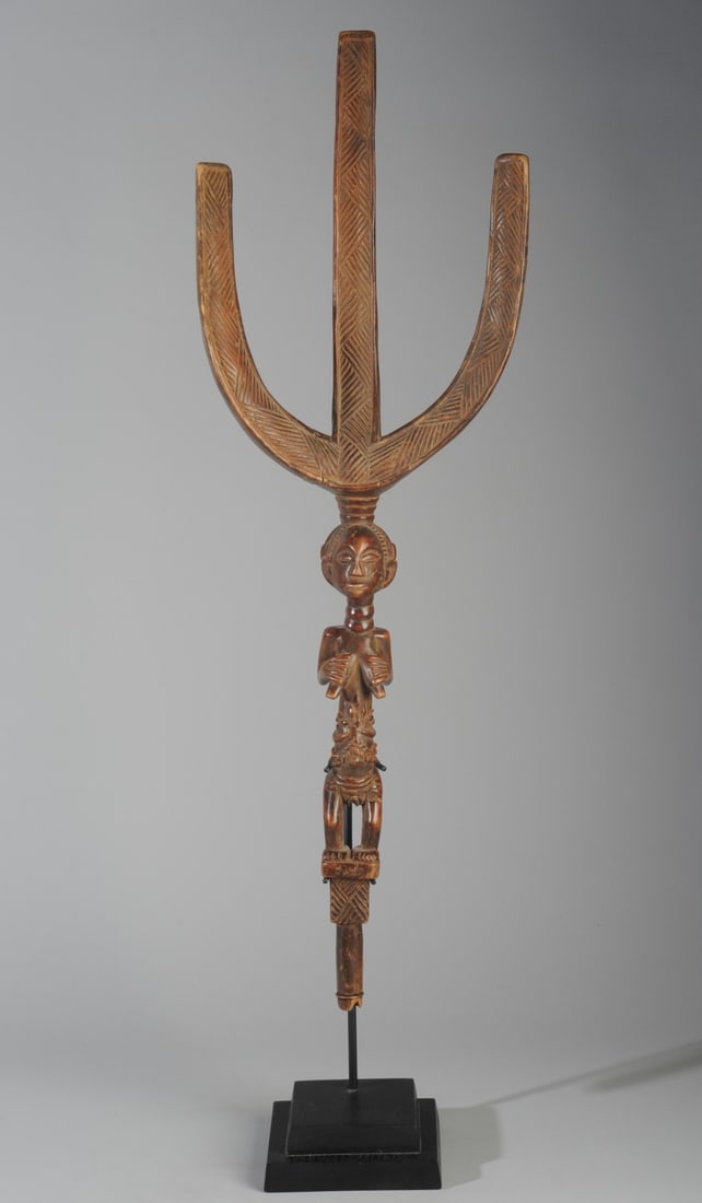 Luba Bow Stand, 'Nsakakabemba', Congo: Finely carved figural bowstand, the tri-part upper section with relief carved diagonal lines arranged to suggest braided hair or woven fibers, this supported by a female figure with elegant coiffure, 