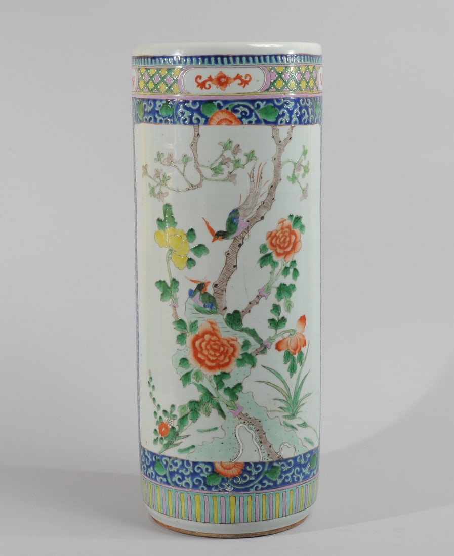 Chinese Famille Rose Umbrella Stand: Porcelain umbrella stand with a scene of a pair of birds among rocks, peonies and prunus, the scene surrounded by turquoise, green, and orange peony scrolls on a cobalt blue ground, with wide borders 