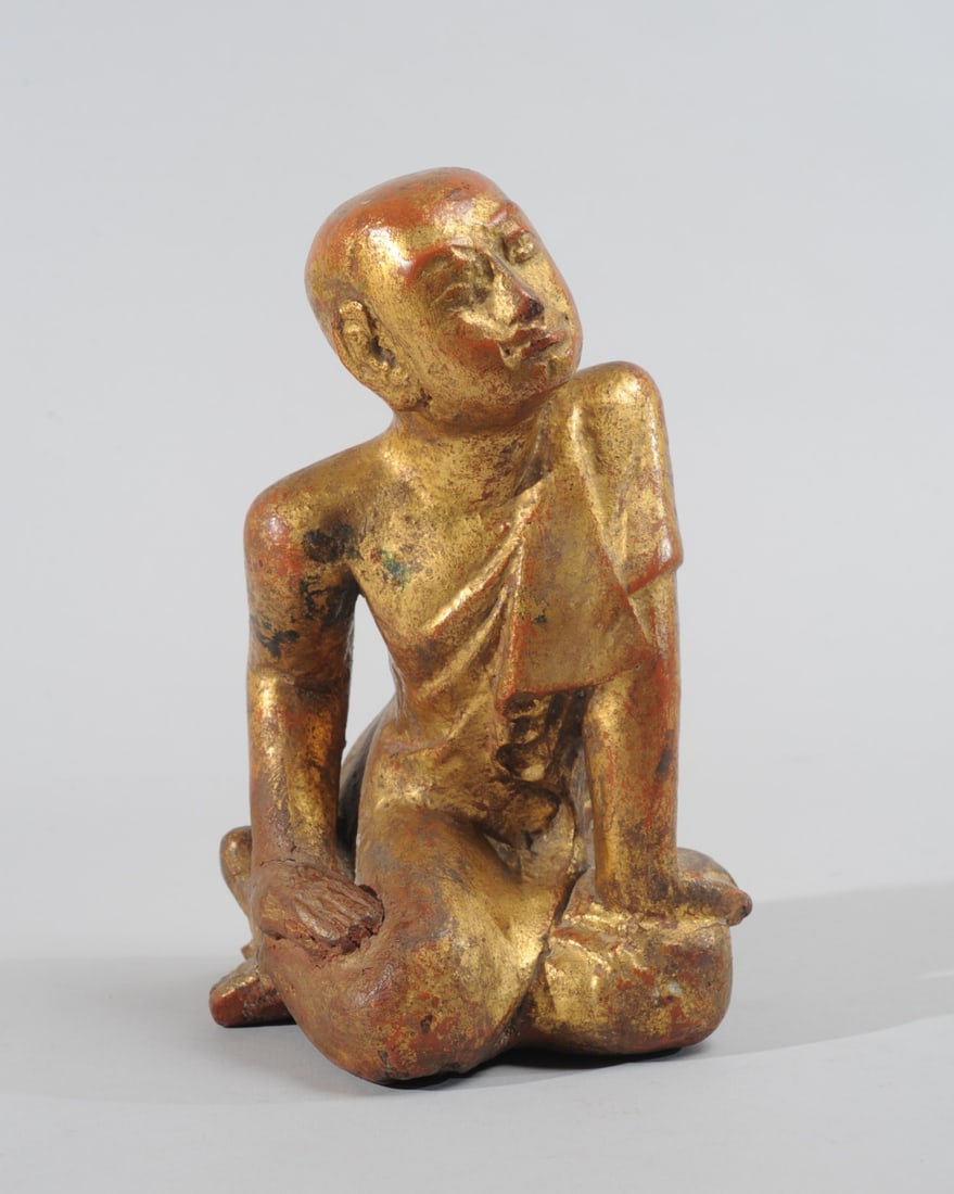 19th C. Burmese Gilt Wood Seated Monk: Carved figure of a seated monk, leaning forward in an attitude of listening. Carved hardwood with red lacquer and gilt. Mandalay period, Burma. Possible repair to one hand. approx. 10" H.