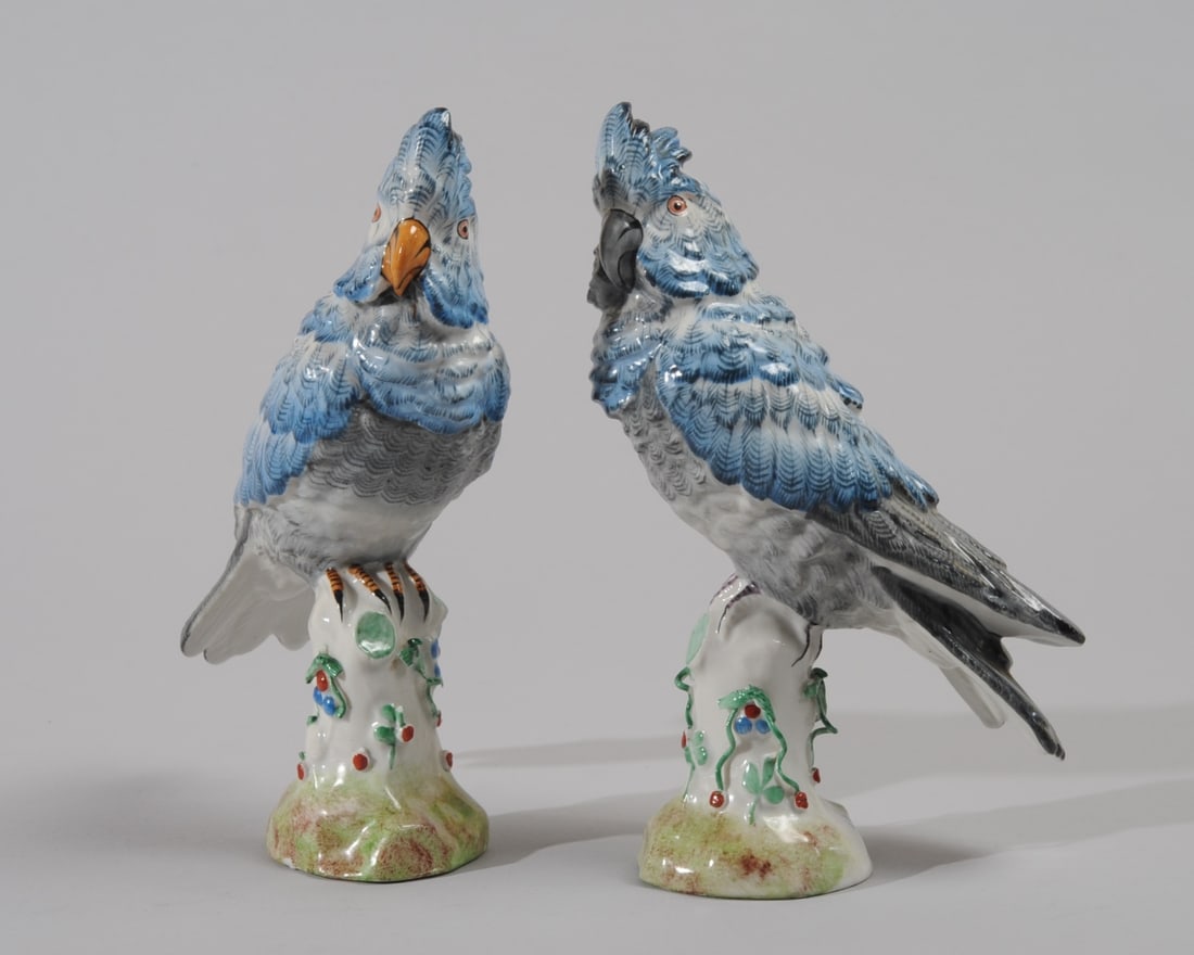Pair Antique French Porcelain Parrots: Finely painted Meissen style blue porcelain parrots, each perched on a stump. Both with mark of Paris pottery Bourdois & Bloch in blue enamel. Losses to some of the small tendrils on the stump. One pa