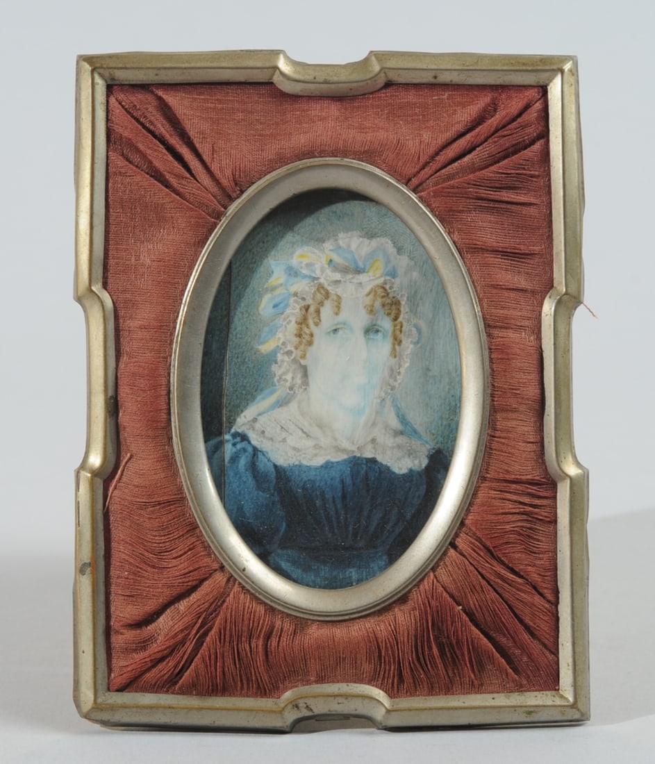 19th C. English Portrait Miniature: Portrait miniature in metal and pleated silk frame showing a woman with brown curls and a beribboned lace cap. Wear or improper cleaning has washed out the image, giving the subject a ghostly look. Fr