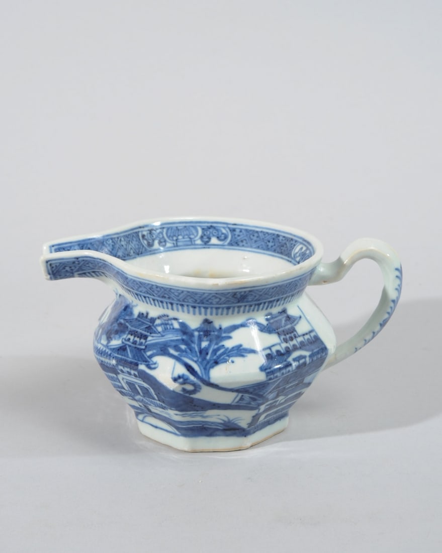 Nanking Chinese Export Porcelain Creamer: Heavily potted Chinese export 19th C. blue and white cream pitcher with octagonal base and sides, decorated with typical Nanking export diaper and spear border and pagoda and mountain lake scenes in u