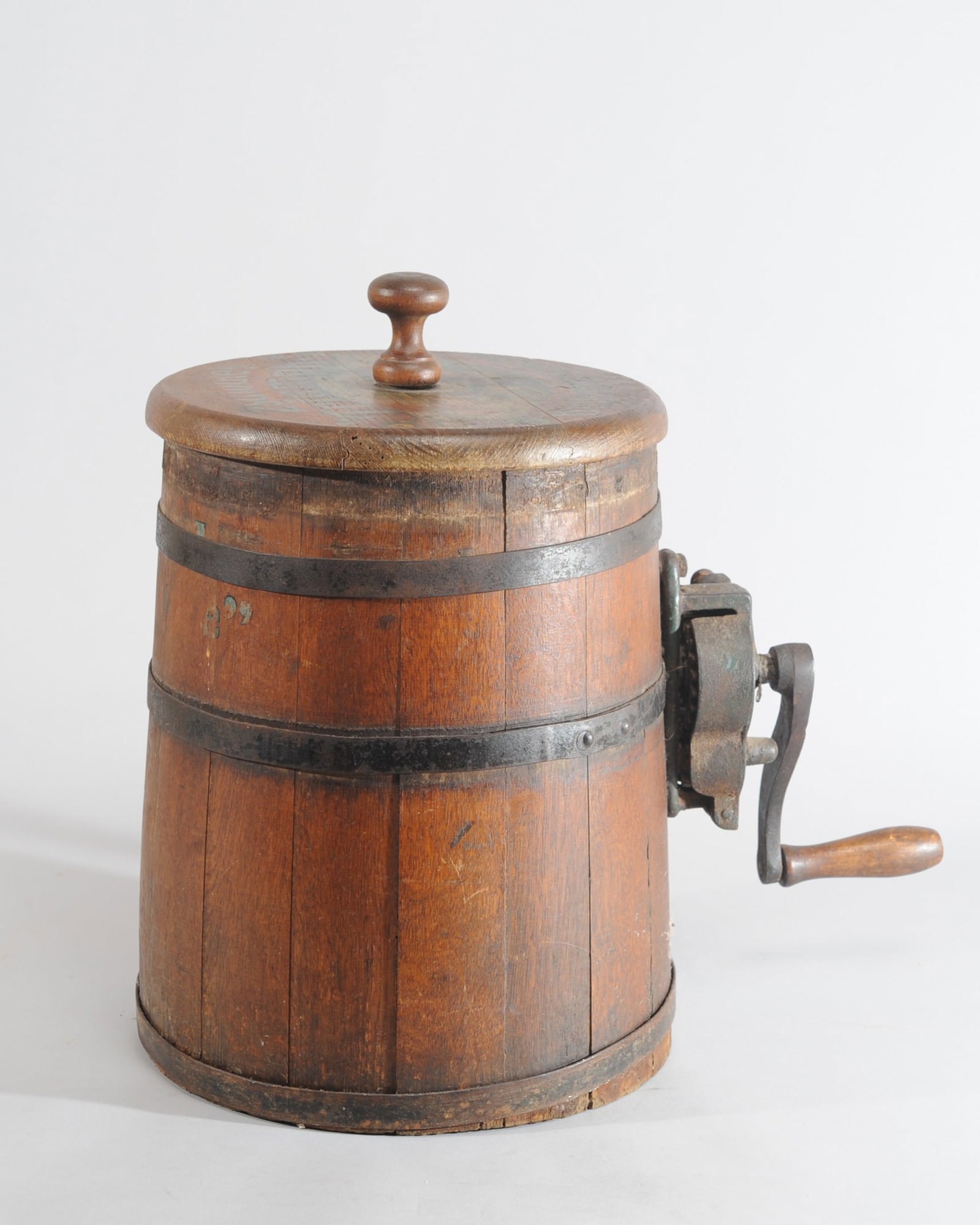 Zschocke's "Triumph" Buttermaschine Butter Churn: Crank handle operated barrel-form butter churn, to lid - "Zschocke's "Triumph" Buttermaschine" with pastoral scene, turns smoothly. H: approx. 17 1/4". Dia: approx. 11". Approx. 17" from edge of barre