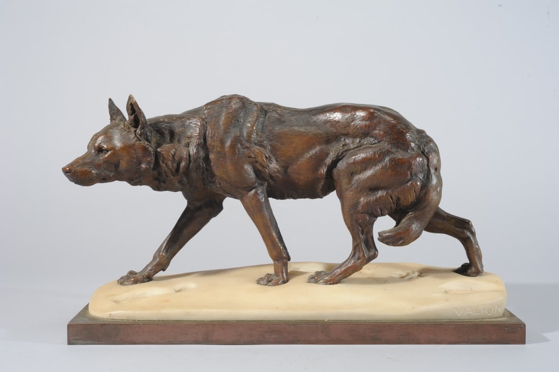 Charles Valton Bronze & Marble, Stalking Wolf: Patinated bronze and marble statue of a stalking wolf in snow, following a path of human footprints, after French sculptor Charles Valton (1851-1918.) Incised signature to white marble: Valton. Mounte