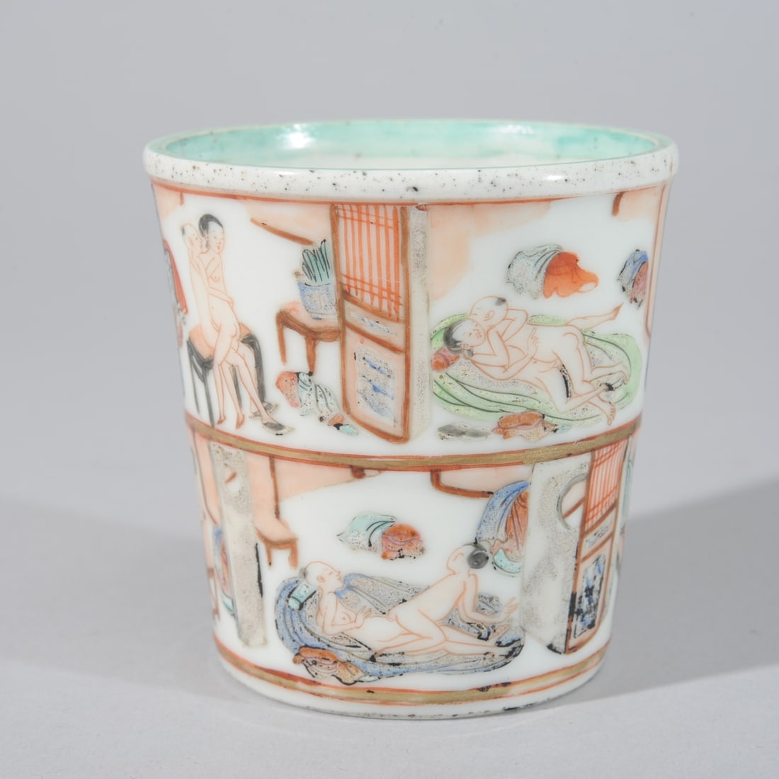 Chinese Qing Erotic Porcelain Cup: Small Chinese porcelain cup with multiple erotic scenes painted on all sides and on the bottom inside and out in famille rose enamels. Great details of tossed garments, architecture and furniture. Pro