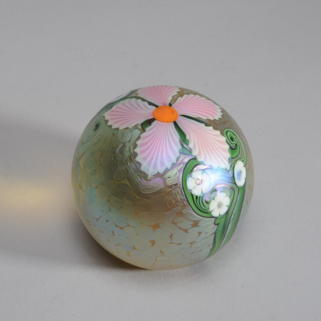 Orient & Flume Richard Braley Paperweight: Art glass paperweight with pink and white flowers on an iridescent yellow oilspot ground. Etched signature Braley to base with Orient & Flume and numerical marks. Approx. 3 1/4" H.