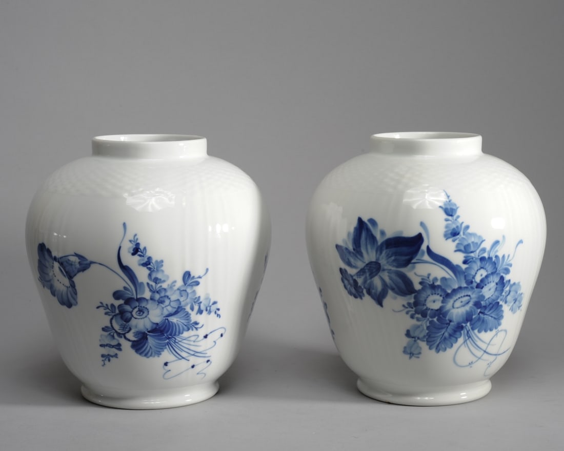 Pair Royal Copenhagen Blue Flower Vases #10/1791: With subtle basket textured surface, decorated with hand painted floral bouquets in blue. One with date mark for 1958, the other with mark for 1969-74. Both approx. 9 1/4" H.