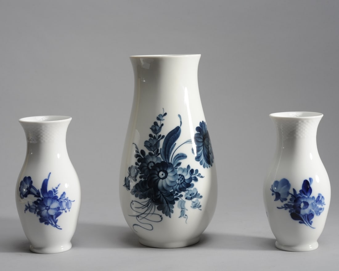 3 Royal Copenhagen Blue Flower Vases: A pair of 7" H blue flower vases with woven basket texture at neck, # 10/8623, offered together with a 10" H blue flower vase, smooth texture, # 45/4144. The two smaller vases with date marks for 1958