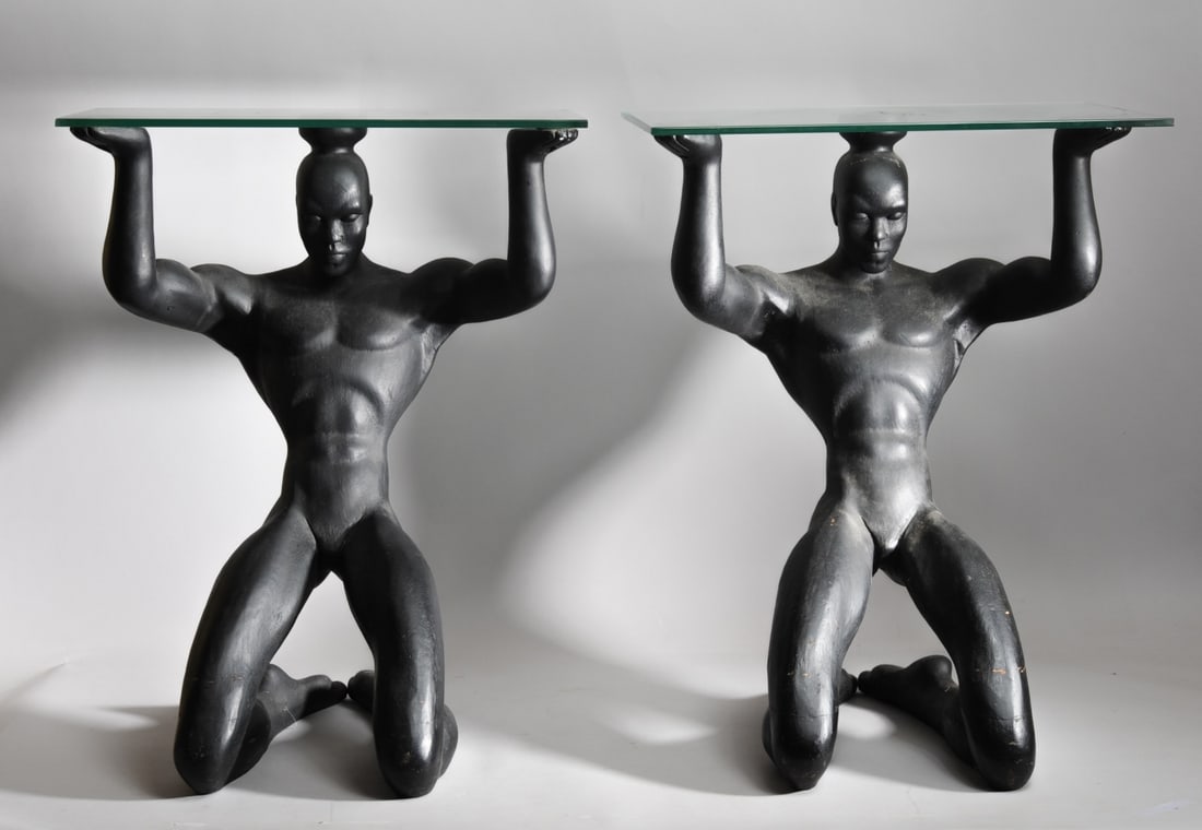 Pair Figural Side Tables, Male Nude Sculptures: Mirror matched pair of glass top side tables, the matte black composition bases in the form of kneeling male nudes. Maker not known. No marks found. Chip to underside of rim on one glass top. When ass