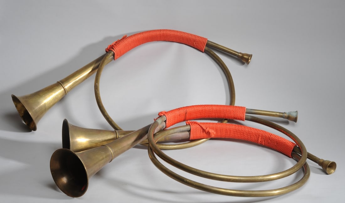 Three Brass Cor de Chasse Hunting Horns: French or French style decorative brass hunting horns with red-orange cording. Each approx. 33 1/2" x 20 1/4" x 6".