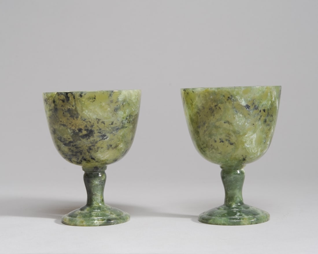 Pair Spinach Jade or Hardstone Wine Cups: Carved stone or jade stemmed cups, green with dark and light inclusions. Both approx. 4 1/8" H.