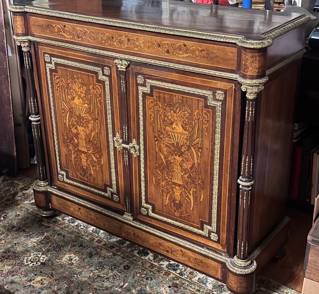 Antique French Louis XVI Style Inlaid Sideboard: With gilt bronze mounts, inlaid floral decorations, shaped top over double doors, turned feet. Some cracks and splitting, losses and damage to veneers and inlay / in as-found condition. H: approx. 44"