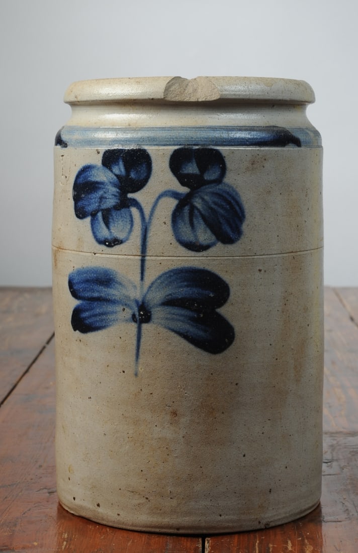 19th C. 1-Gallon Stoneware Crock: Circa 1850, with floral decoration, large chip to front of rim. H: approx. 10 1/2". Dia: approx. 6 1/2". Seamless shipping is available through LiveAuctioneers at checkout, but you are welcome to arra