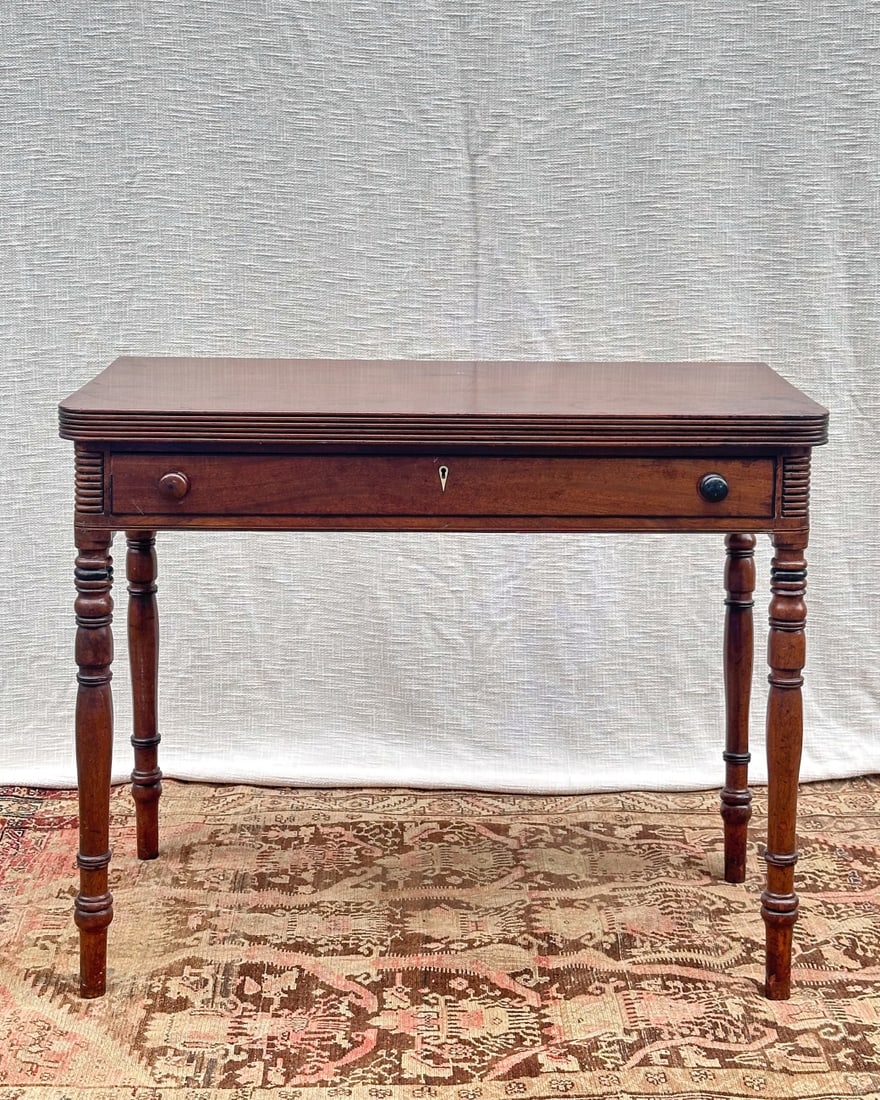 Regency Games Table: Circa 1815, mahogany, ebony inlay, bone escutcheon, some damage / as-found condition. H: approx. 30 1/2". W: approx. 37 3/4". D: approx. 20" (closed). VHC 72. Please note: This lot is located off-site