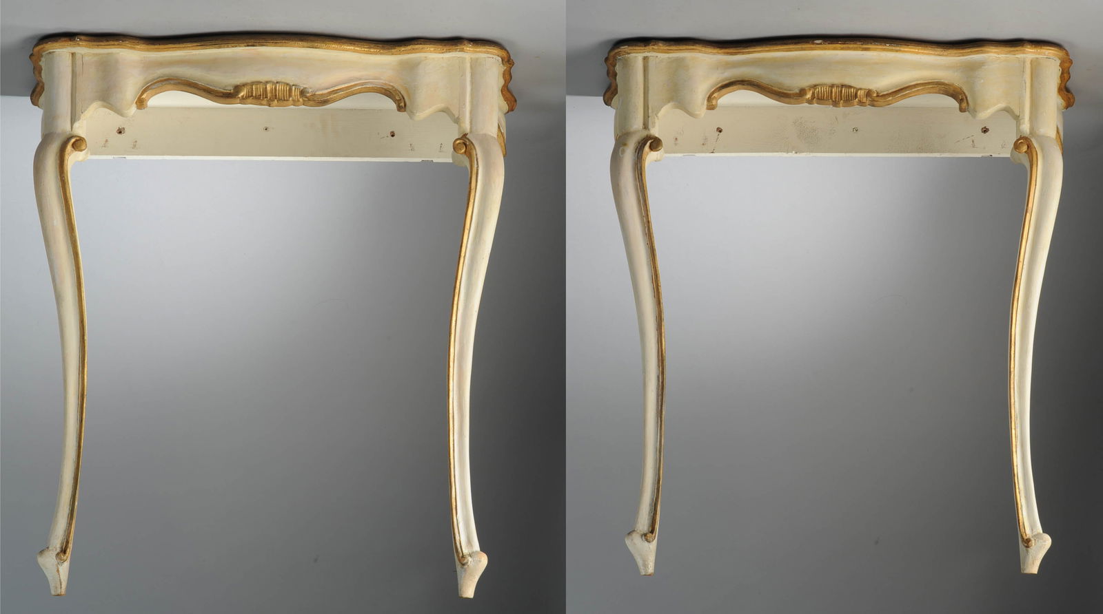 Pair of Italian Painted and Gilt Console Tables: Pair of painted and gilt wood console tables, each with faux marble painted serpentine tops, shaped aprons, and two front cabriole legs. Designed to be placed against a wall (no back legs). One shows