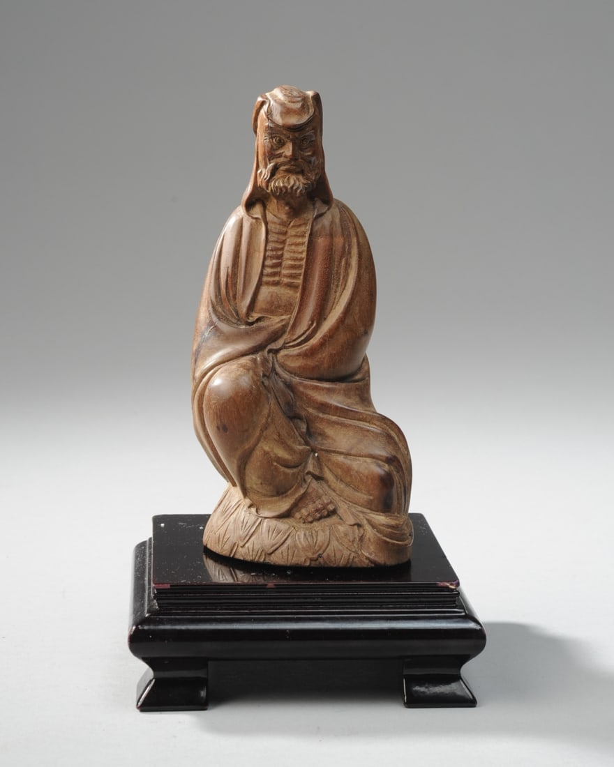 Chinese Carved Hardwood Bodhidharma Figure: Robed figure of Bodhidharma, seated on a lotus throne. Carved of very dense hard wood with tiny dark knots, likely Suanzhi wood. Late Qing - early Republic. Includes later square lacquered stand. Figu