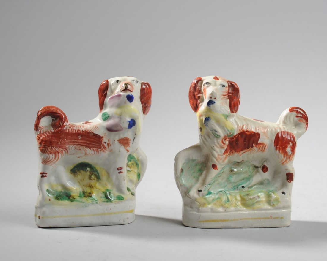 Pair 19th C. Staffordshire Spaniel Figures: Circa mid 19th century, flatback form, each modeled standing with a bird clasped in its mouth, a charming example of the more rustic, folk style of Staffordshire mantelpiece figures. Typical minor fir