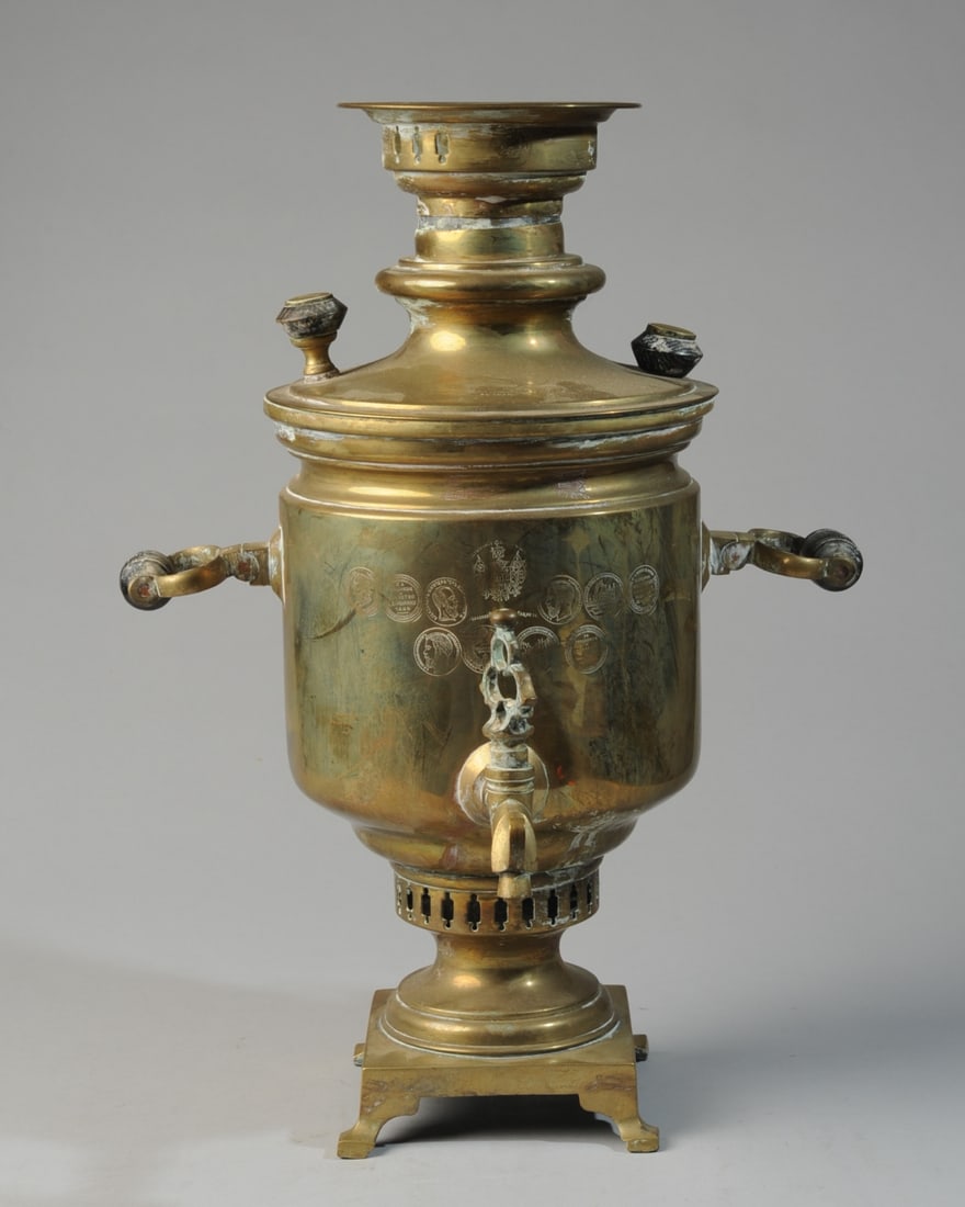 Russian Brass Samovar, Vanykin: Tula circa 1895 - 1905, urn shaped brass samovar on square base engraved with numerous exhibition and society medals, including portraits of Alexander III and Nicholas II, the all Russian Industrial a