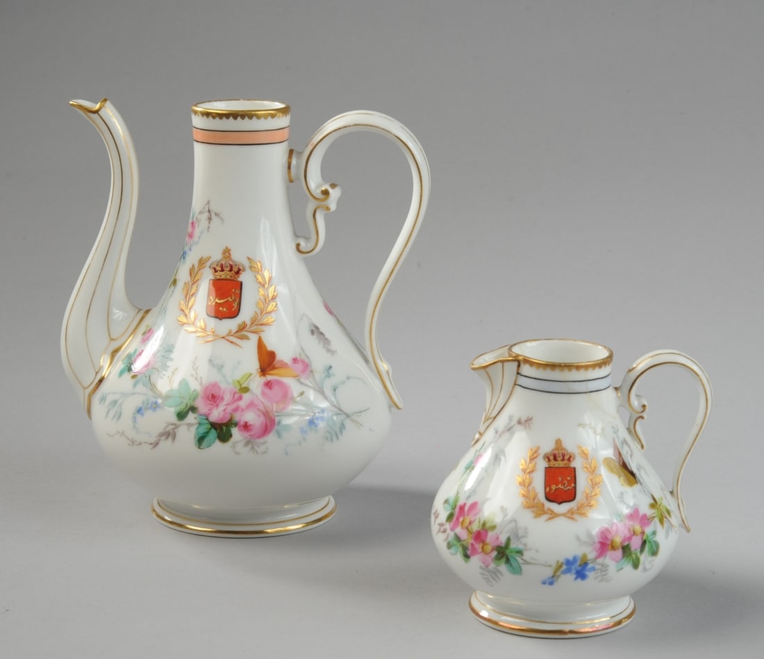 French Colonial Porcelain Ewers, Tunisia: c. 1880-1930 (possibly later, but before 1957,) porcelain coffee ewer and cream pitcher, decorated with armorial device showing a beylical crown with star and moon above a red shield with Arabic inscr